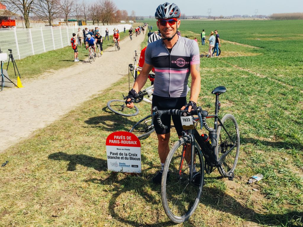 Ciclista in posa accanto a un cartello stradale, Parigi-Roubaix, Francia.