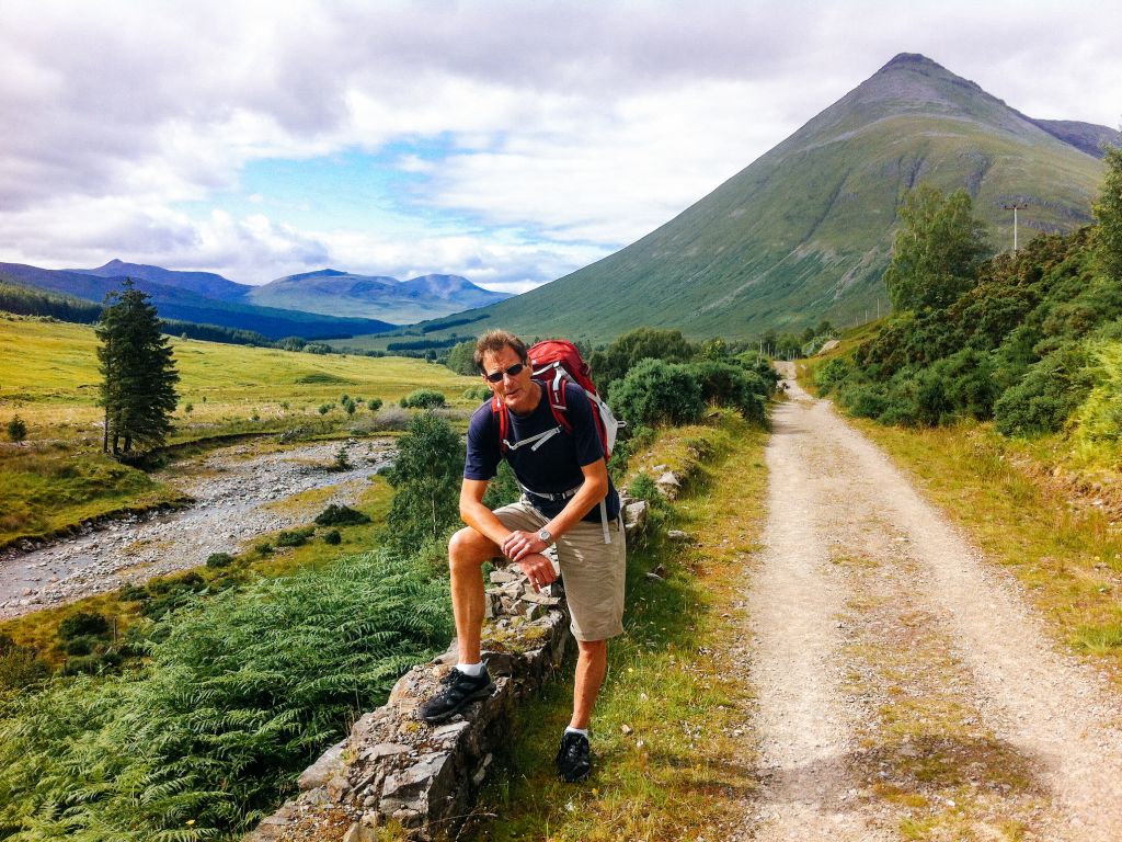 Escursionista su un sentiero di montagna con paesaggio collinare, West Highland Way