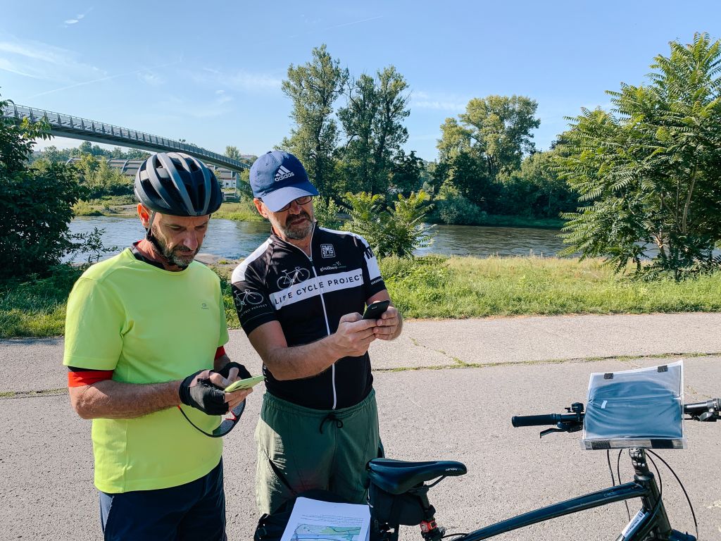 Coppia di ciclisti che osserva il percorso da fare tramite app su smartphone, viaggi in bici organizzati "Girolibero"