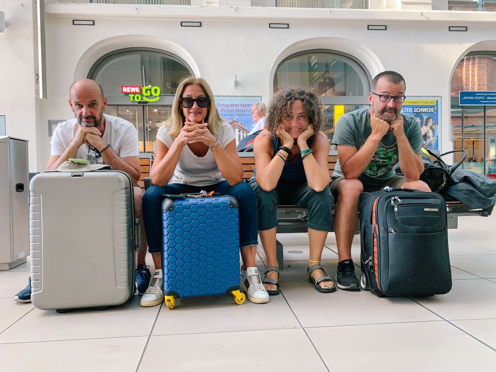 Viaggiatori seduti con valigie in un aeroporto internazionale.