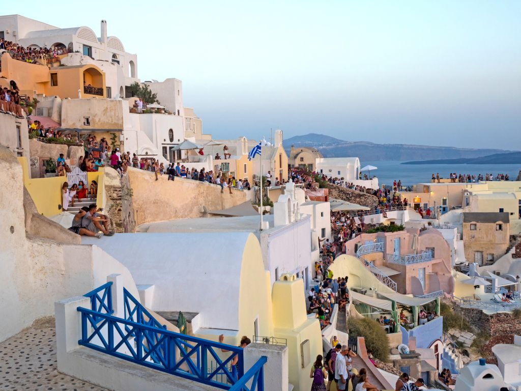 Porto di Santorini con barche ormeggiate e case colorate, Grecia.