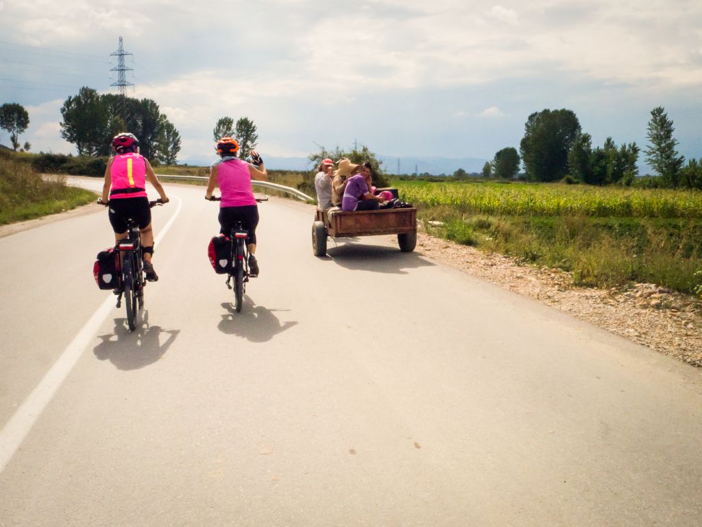 Due persone in bicicletta lungo una strada rurale panoramica in Albania, viaggi in bici "Girolibero"
