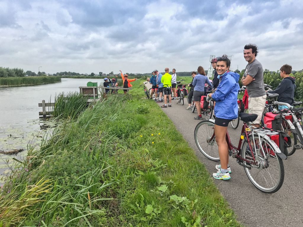 Ciclisti su una pista ciclabile in campagna vicino a un canale, viaggi in bici "Girolibero", Olanda