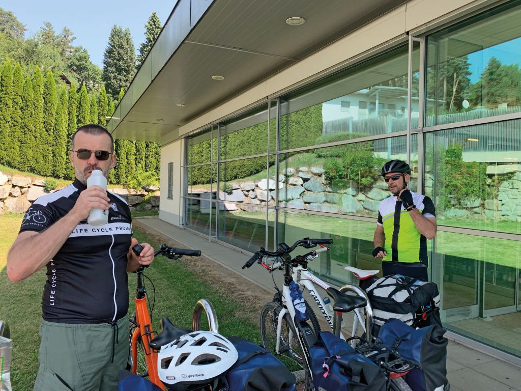 Ciclisti con le bici parcheggiate fuori da una stazione ferroviaria in Tirolo, Austria