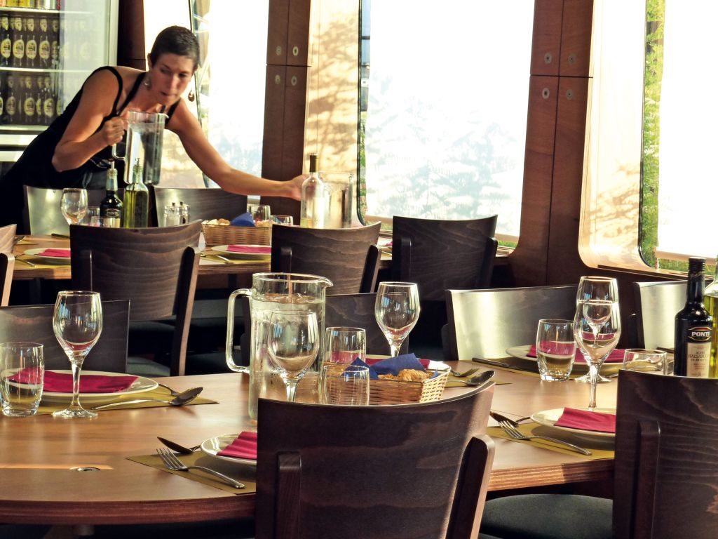 Waiter setting the table in the onboard restaurant of a luxury gulet.