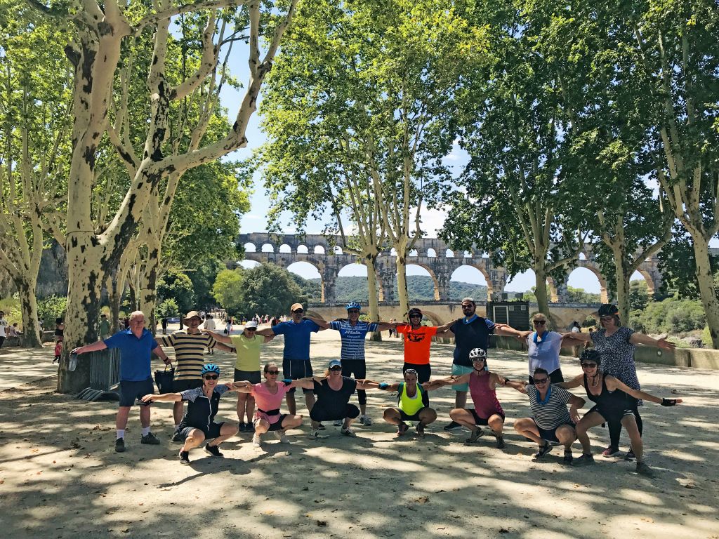 Ciclisti che si riposano sotto gli alberi in un parco in Provenza, vacanze di gruppo in bicicletta