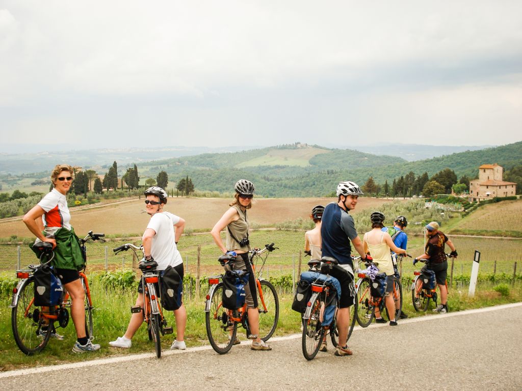 Gruppe von Radfahrern auf einer Landstraße mit Blick auf die Hügel der Toskana