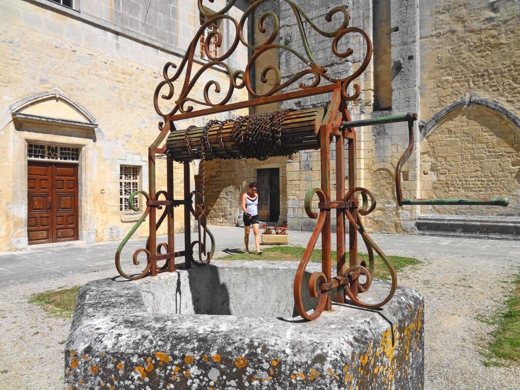 Vecchio pozzo in pietra, turista in visita ad un edificio storico, Francia