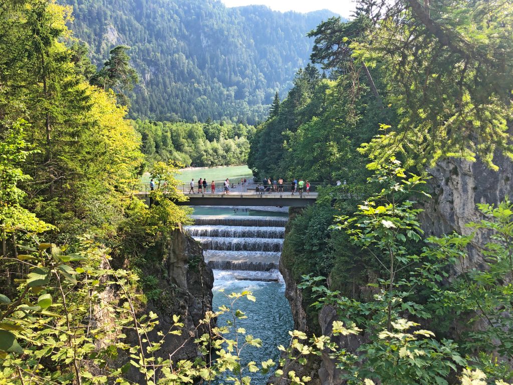 Ponte sospeso tra le montagne con boschi verdi lungo la Via Claudia Augusta, Tirolo, Austria