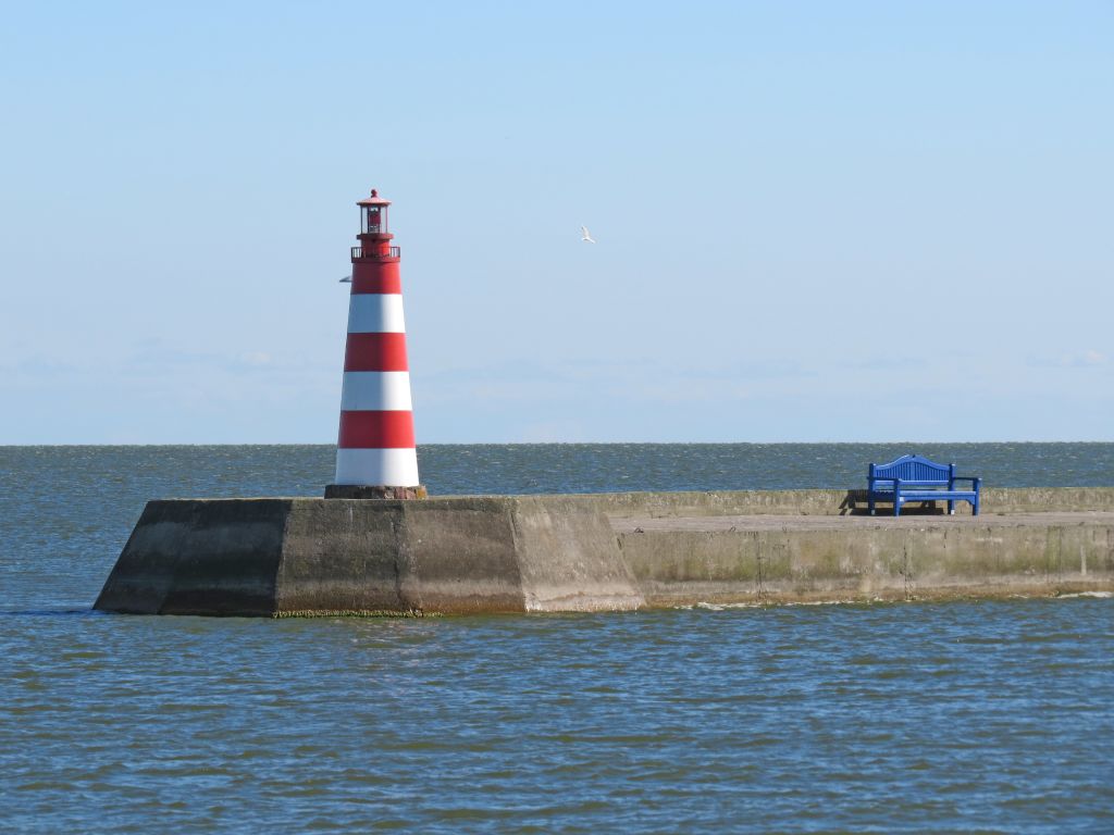 Faro rosso e bianco su un molo che si estende nel Mar Baltico, Penisola dei Curi, Lituania.
