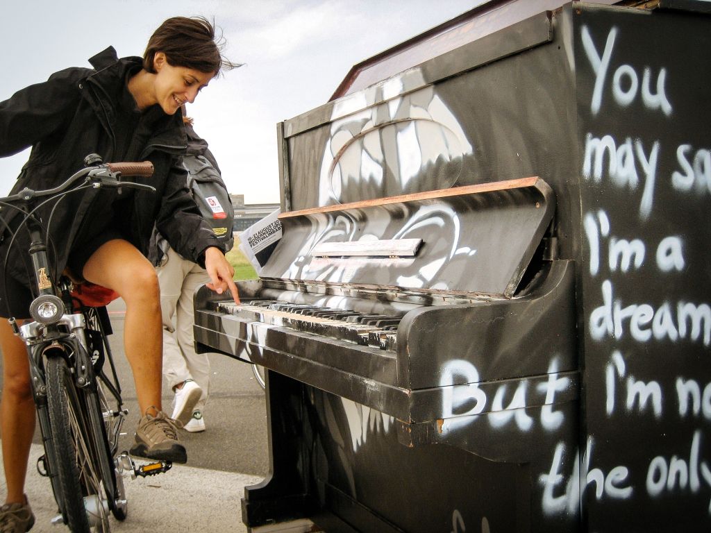 Ragazza in bici vicino a un vecchio pianoforte, centro di Berlino