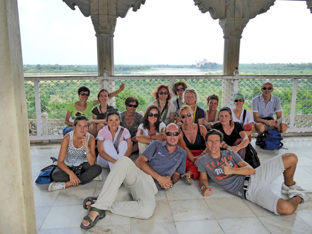 Gruppo di turisti in posa davanti a colonne di un palazzo antico, Palazzo dei Venti, Rajasthan