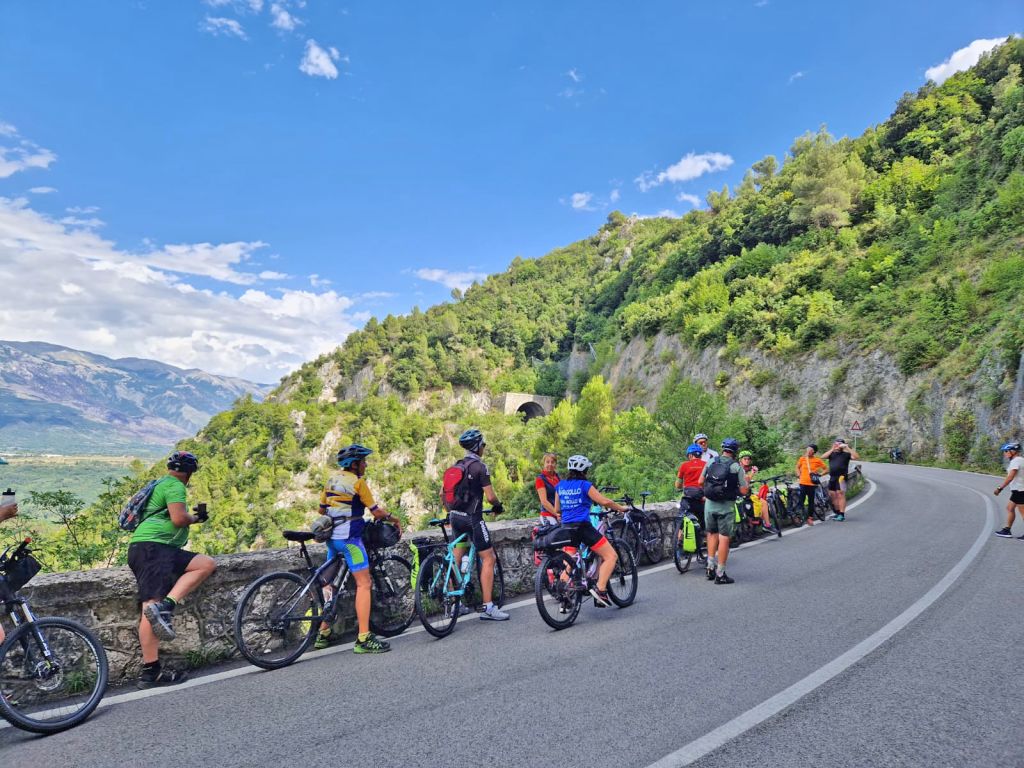 Gruppo di ciclisti in fila su una strada di montagna, Gran Sasso, Abruzzo, Italia