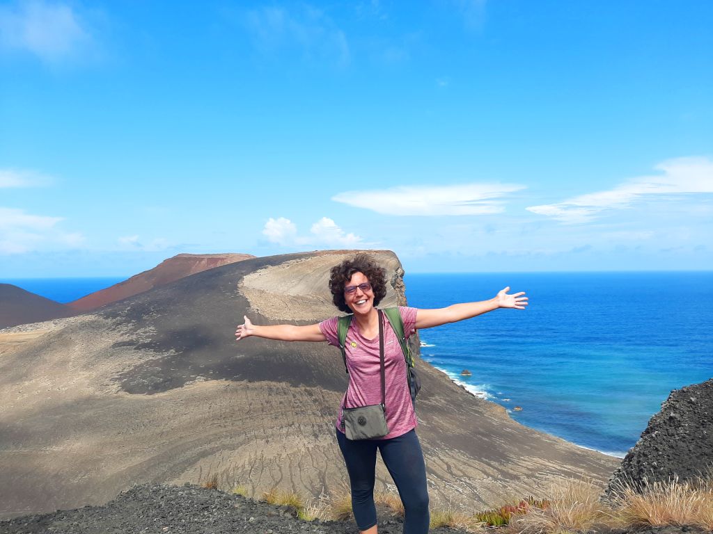 Escursionista con le braccia aperte su una scogliera, Pico Island, Azzorre.