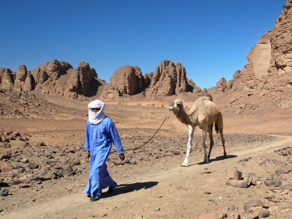 Nomade tuareg con cammello, Algeria - Uomo in abiti tradizionali che guida un cammello nelle distese desertiche del Sahara. Viaggi in gruppo con Girolibero.