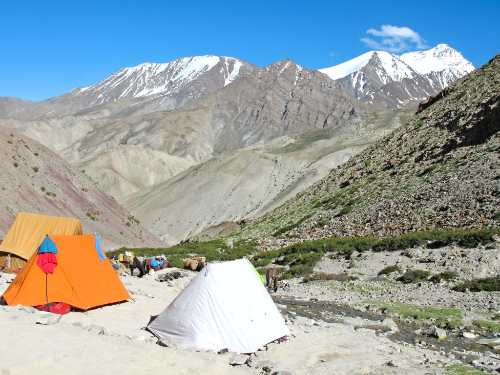 Tenda da campeggio in una valle dell’Himalaya con vista sulle cime innevate del Ladakh.
