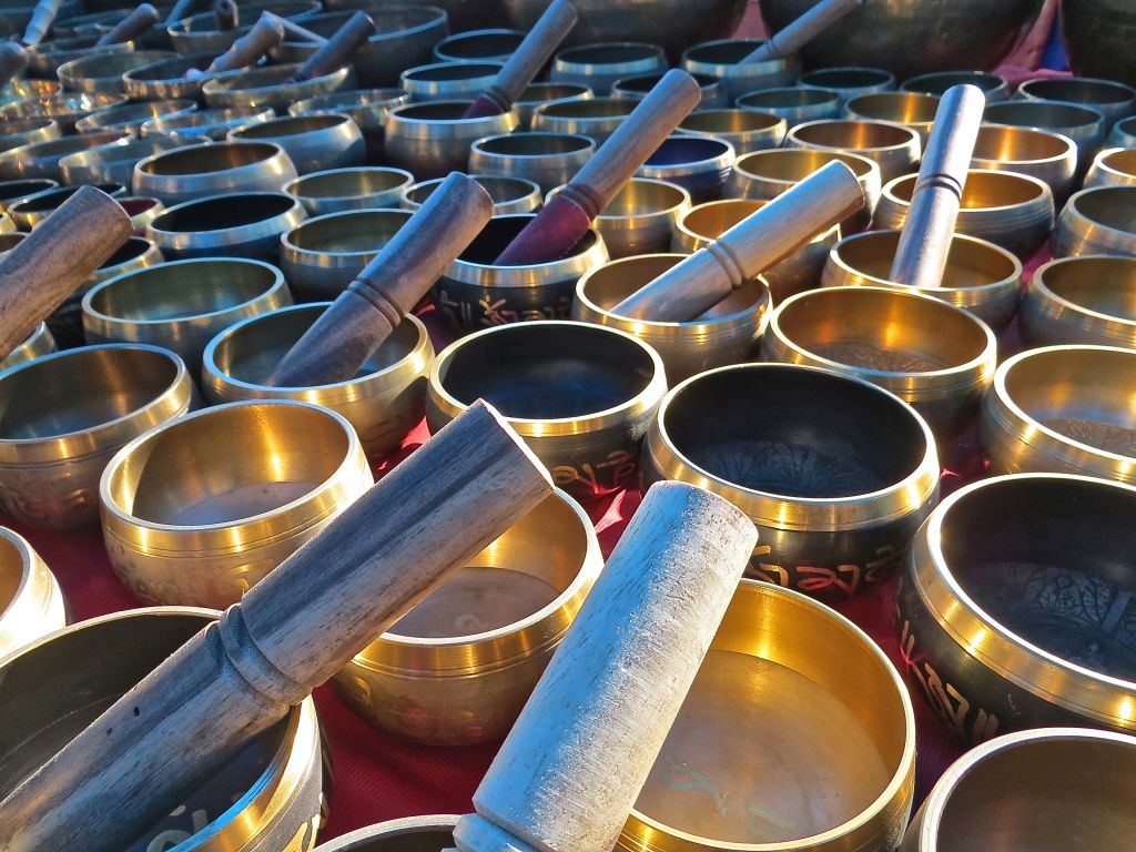 Ciotole tibetane in rame e ottone con bastoncini di legno in un mercato artigianale a Leh.