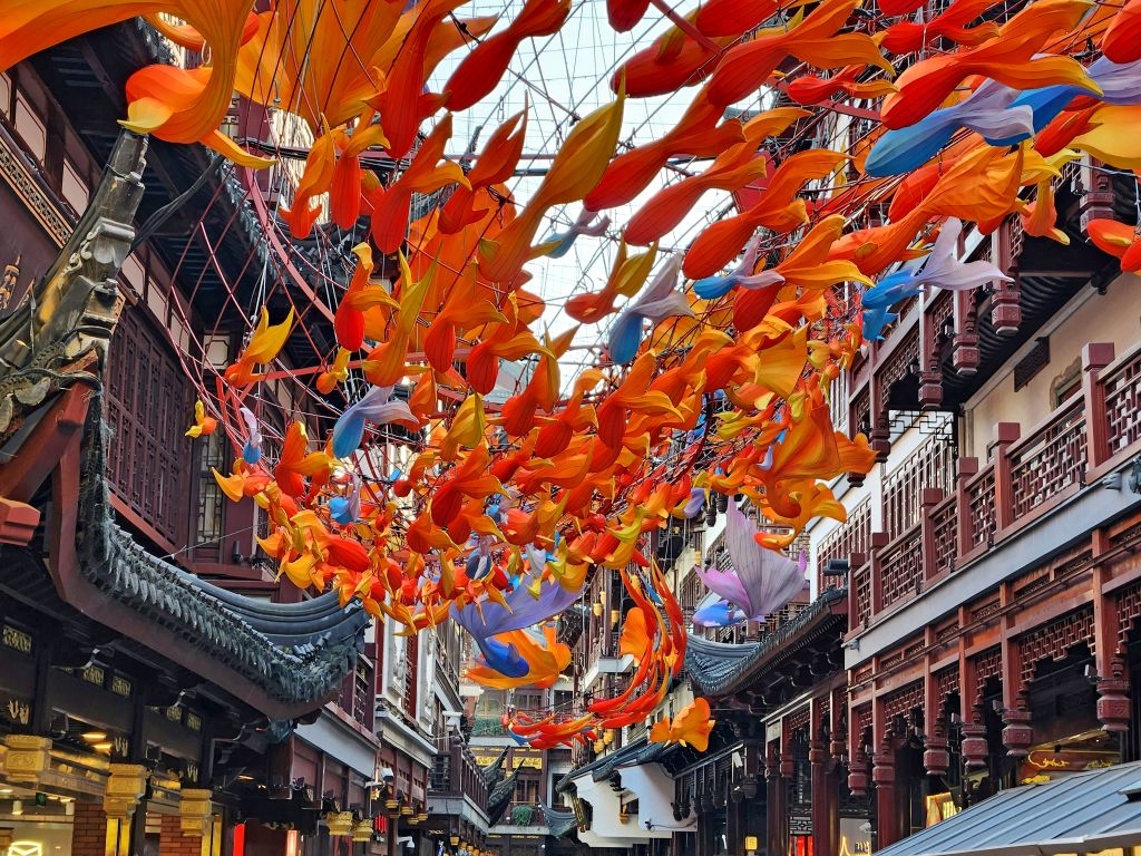 Antica via di Shanghai addobbata con ombrelli di carta arancioni, perfetta per passeggiate fotografiche