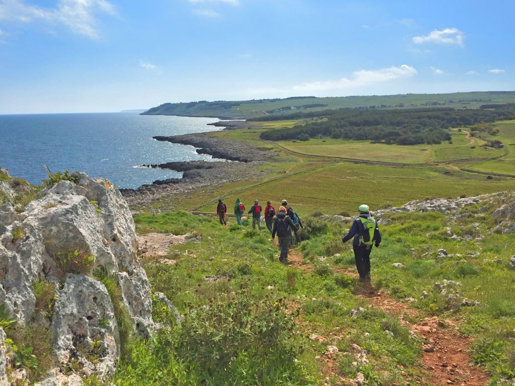 Escursionisti lungo un trekking costiero in Salento.