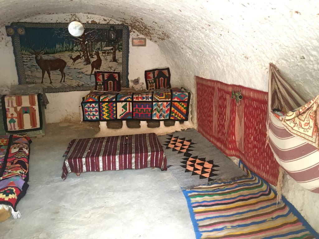 Interno con tappeti berberi in una dimora troglodita di Matmata, Tunisia