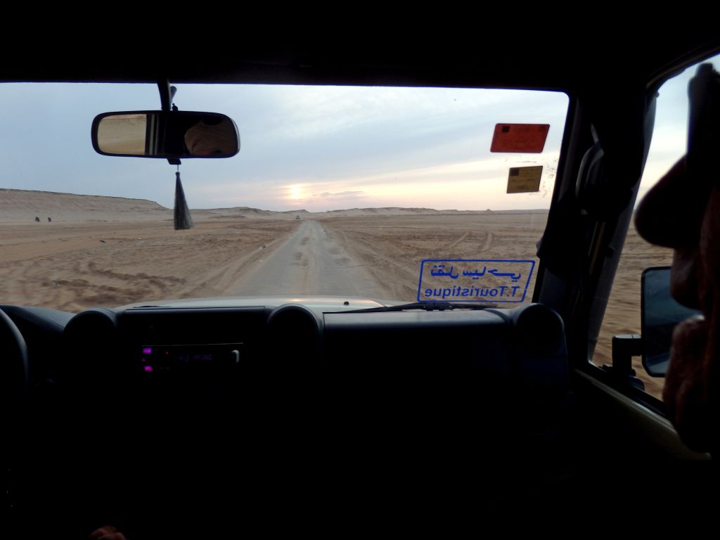 Pista desertica al tramonto vista dall’abitacolo di un 4×4, Tunisia