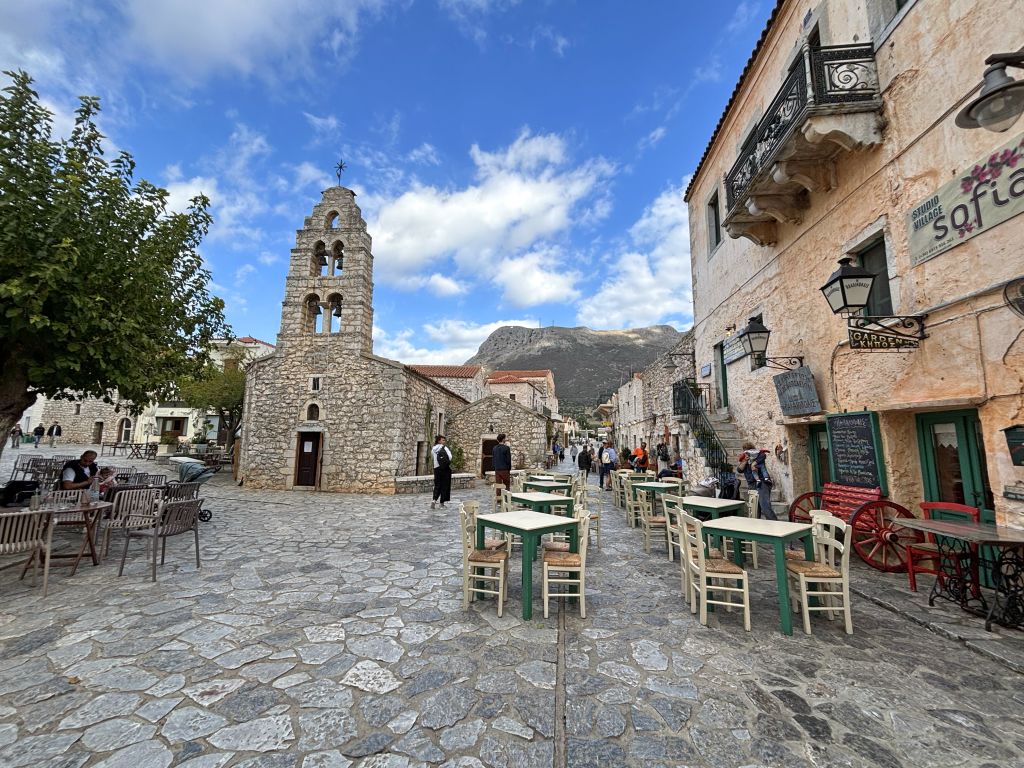 Piazza storica di Aeropoli con taverne tradizionali e atmosfera medievale.