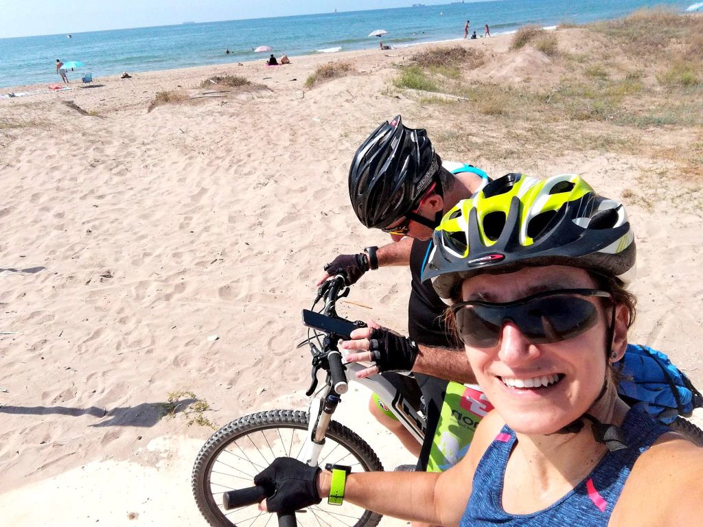 Ciclista sulla spiaggia della costa valenciana durante un tour in bicicletta.