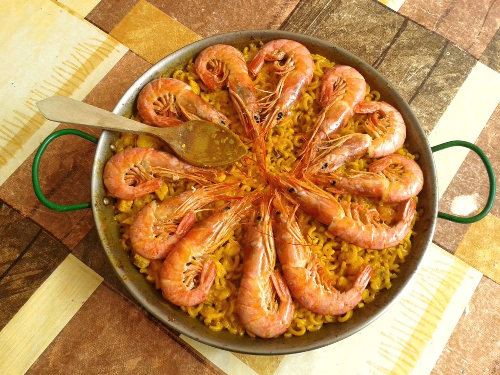 Paella valenciana tradizionale vista dall’alto, piatto tipico della cucina locale.