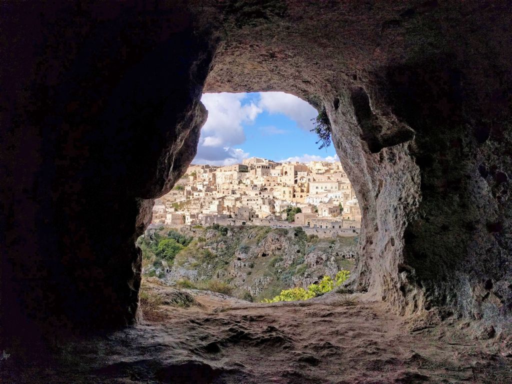 Veduta dei Sassi di Matera attraverso una grotta naturale, esperienza di esplorazione urbana e trekking culturale
