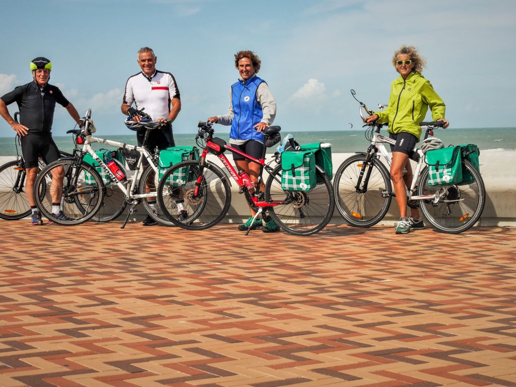 Gruppo di ciclisti in viaggio con "Girolibero" fermi su una piazzetta lungo la costa fiamminga
