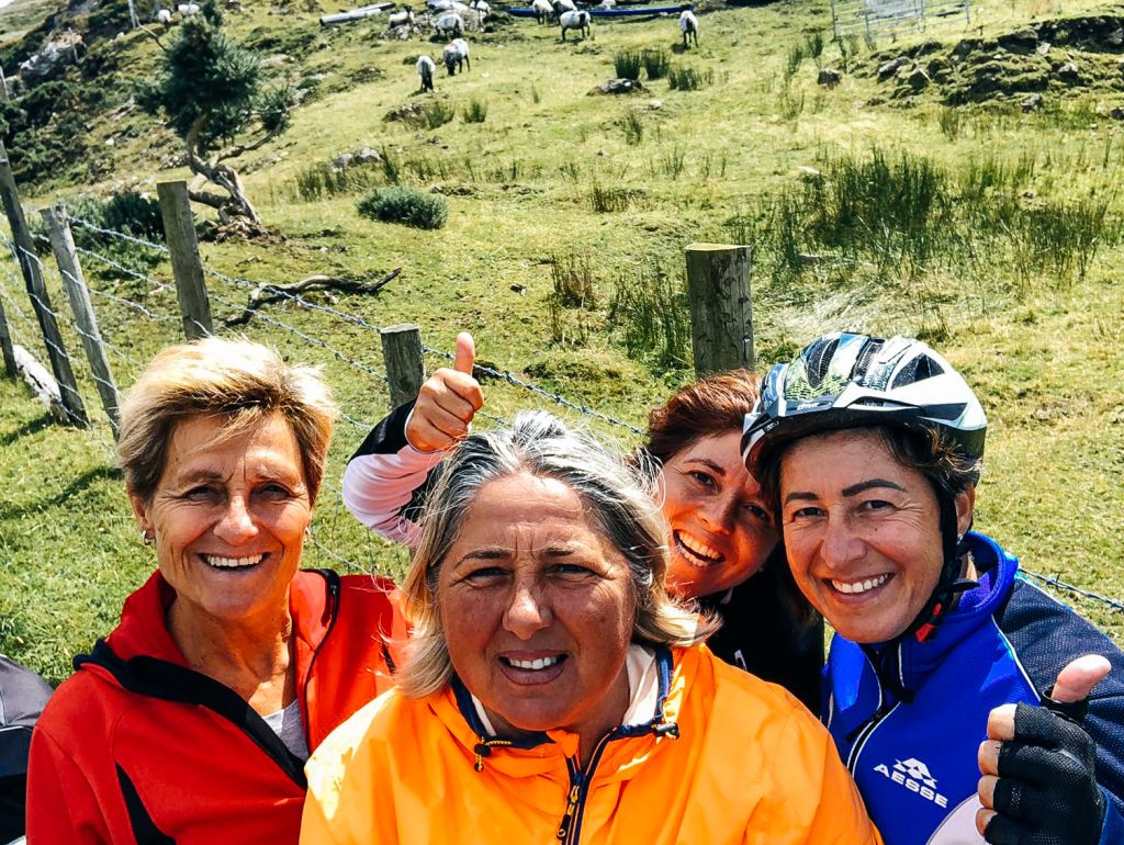 Gruppo di amici sorridenti in bicicletta tra i paesaggi verdi del Connemara, Irlanda in bici "Girolibero"