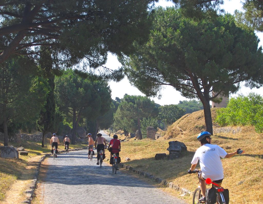Gruppo di ciclisti in viaggio con Girolibero lungo Via Appia Antica a Roma. Vacanze in bicicletta