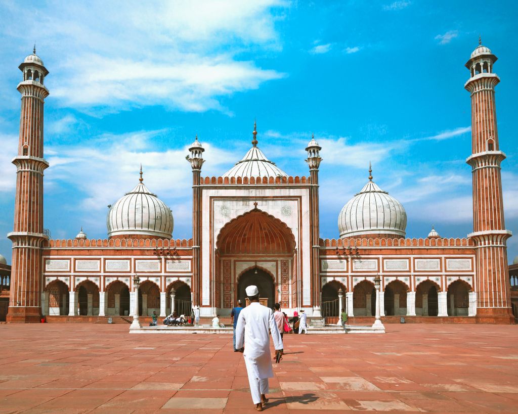 Ingresso della Moschea Jama Masjid di Delhi con uomo in primo piano, India.