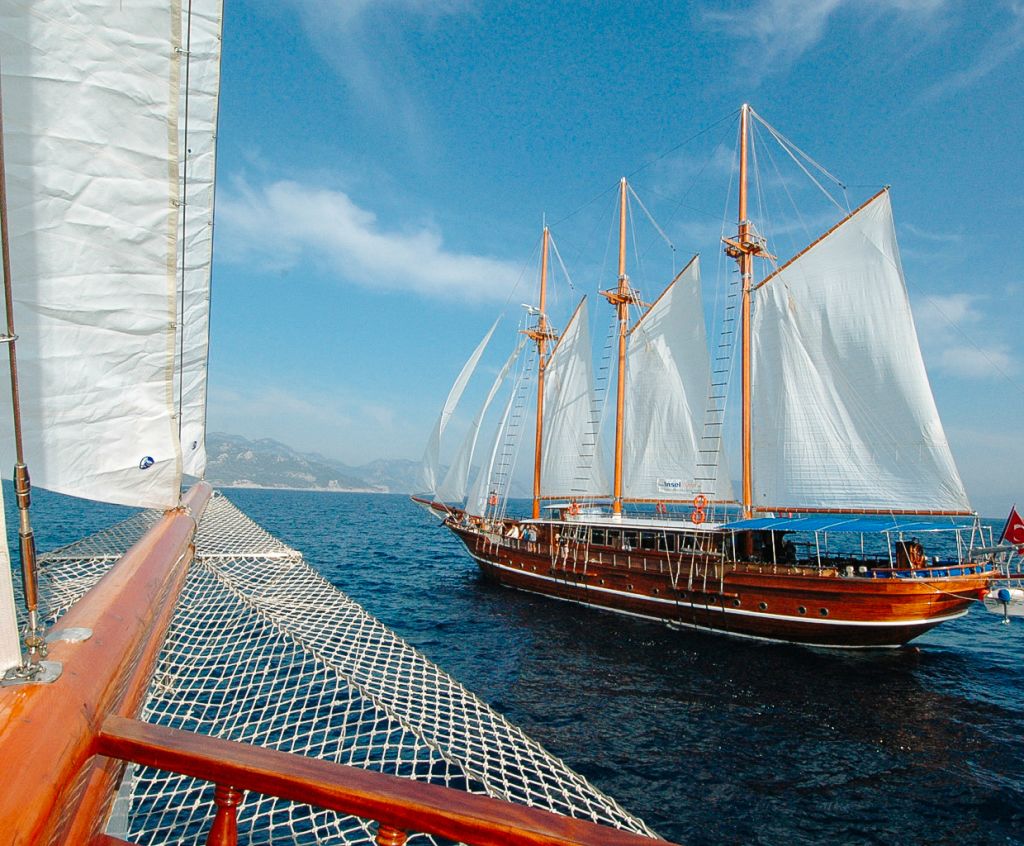 Barca a vela "Thalassa" con vele spiegate naviga vicino alla costa di Atene, Grecia.