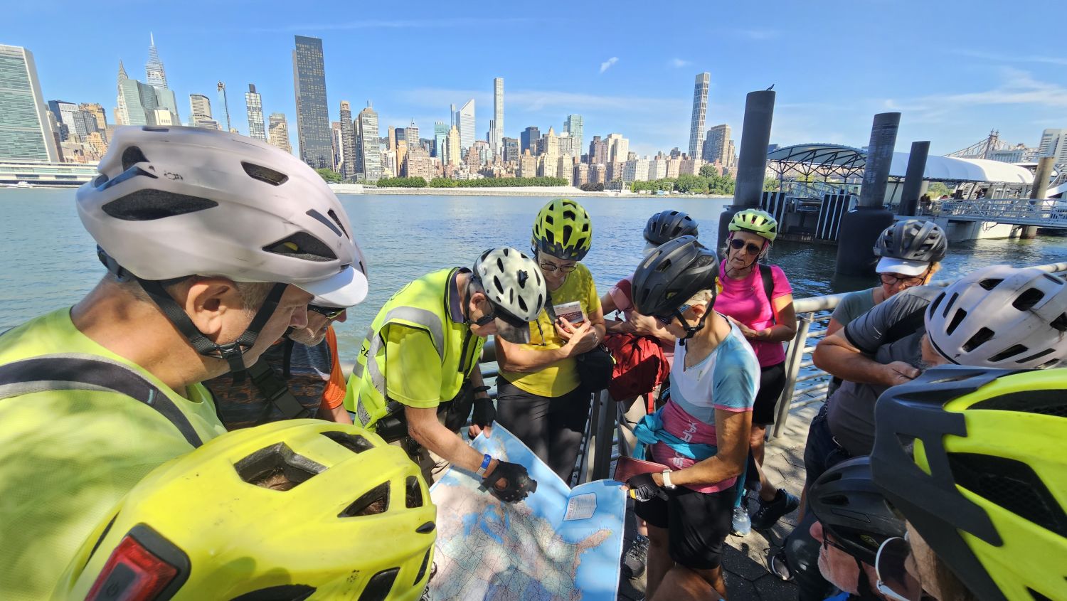 Gruppo di cicloturisti Girolibero durante un tour in bicicletta a New York con vista sullo skyline di Manhattan.