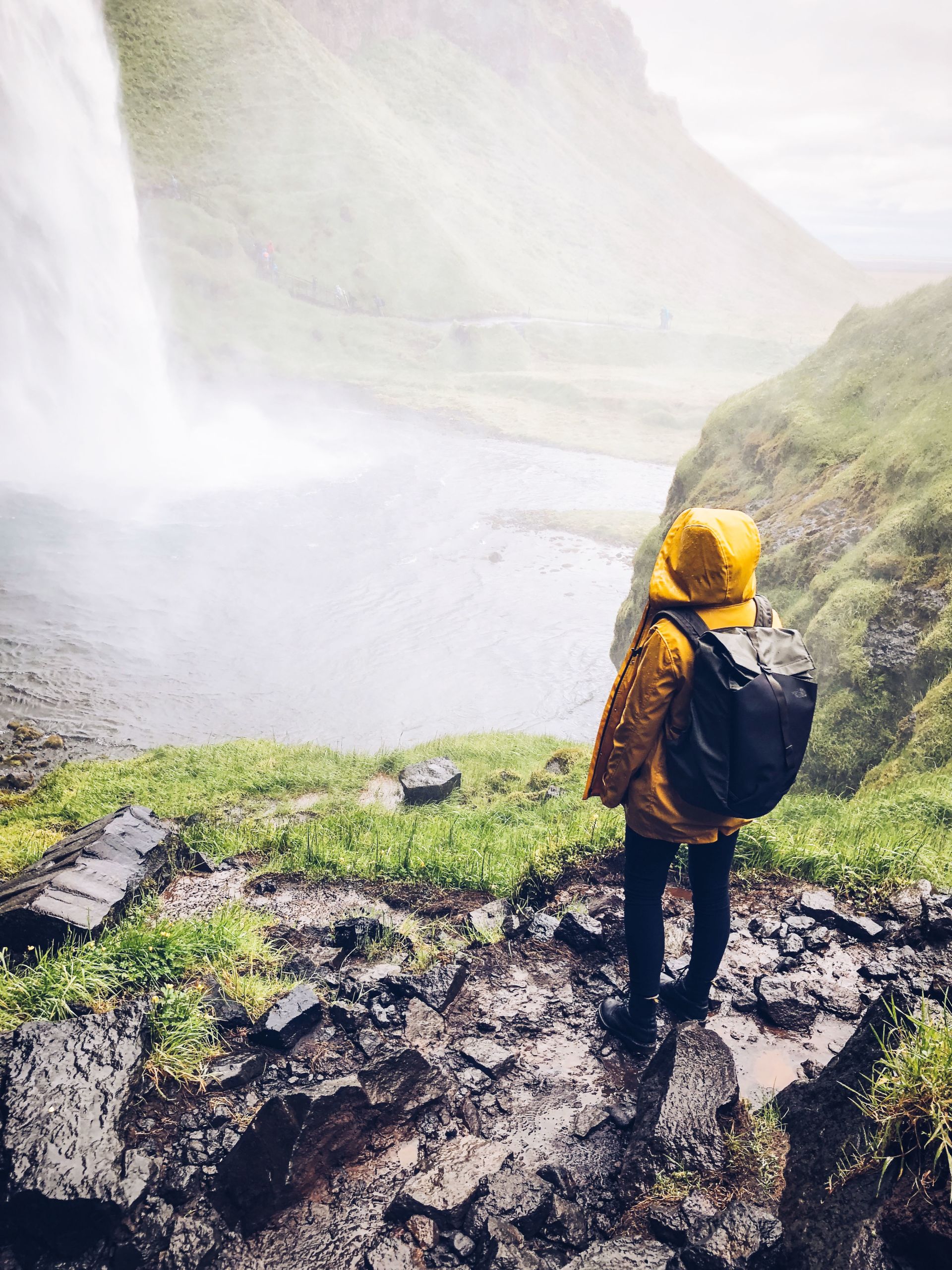 Escursionista vicino a una cascata nella regione di Landmannalaugar, Islanda.