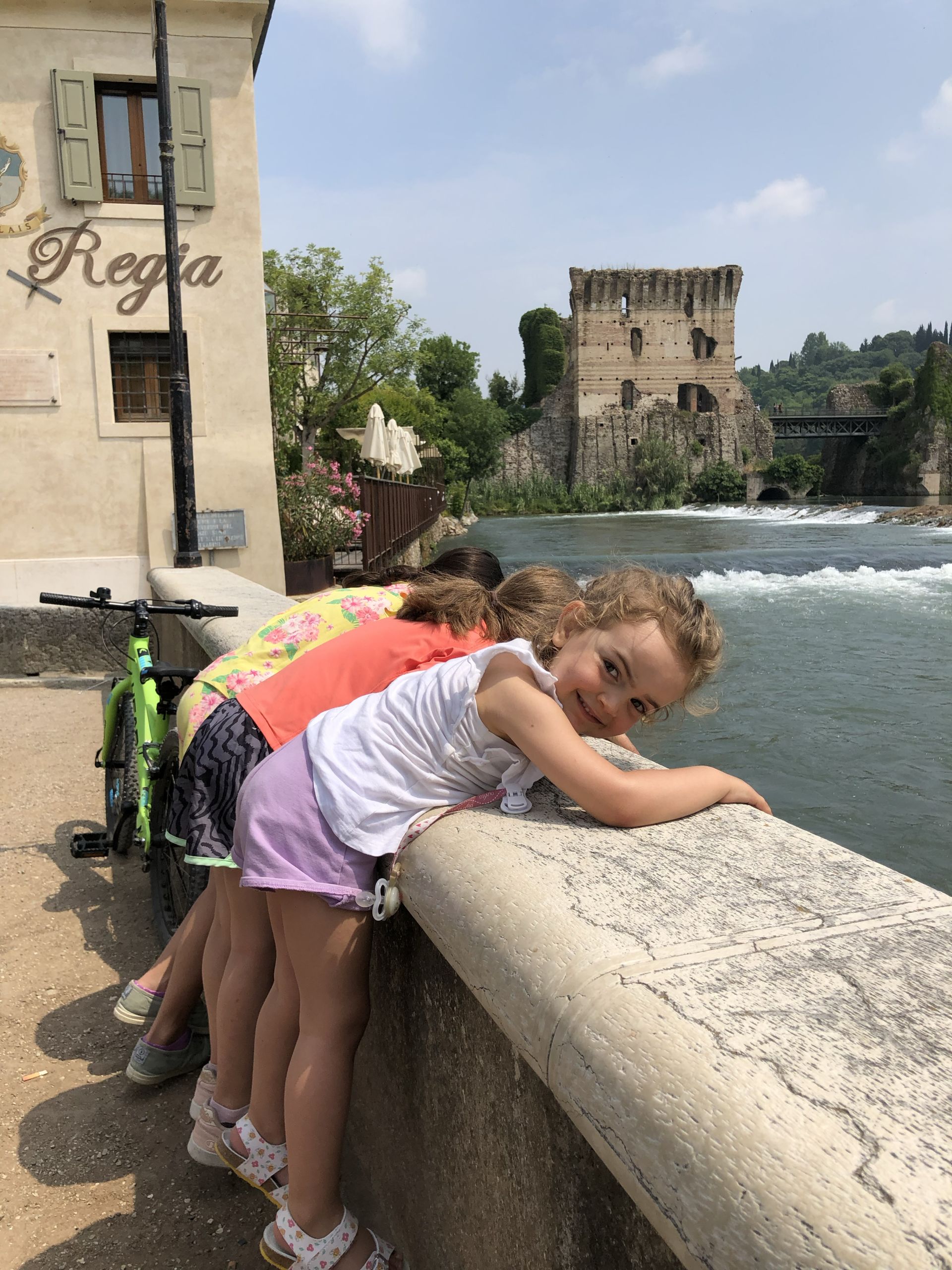Bambini osservano il fiume Mincio scorrere, vacanze in bici in famiglia