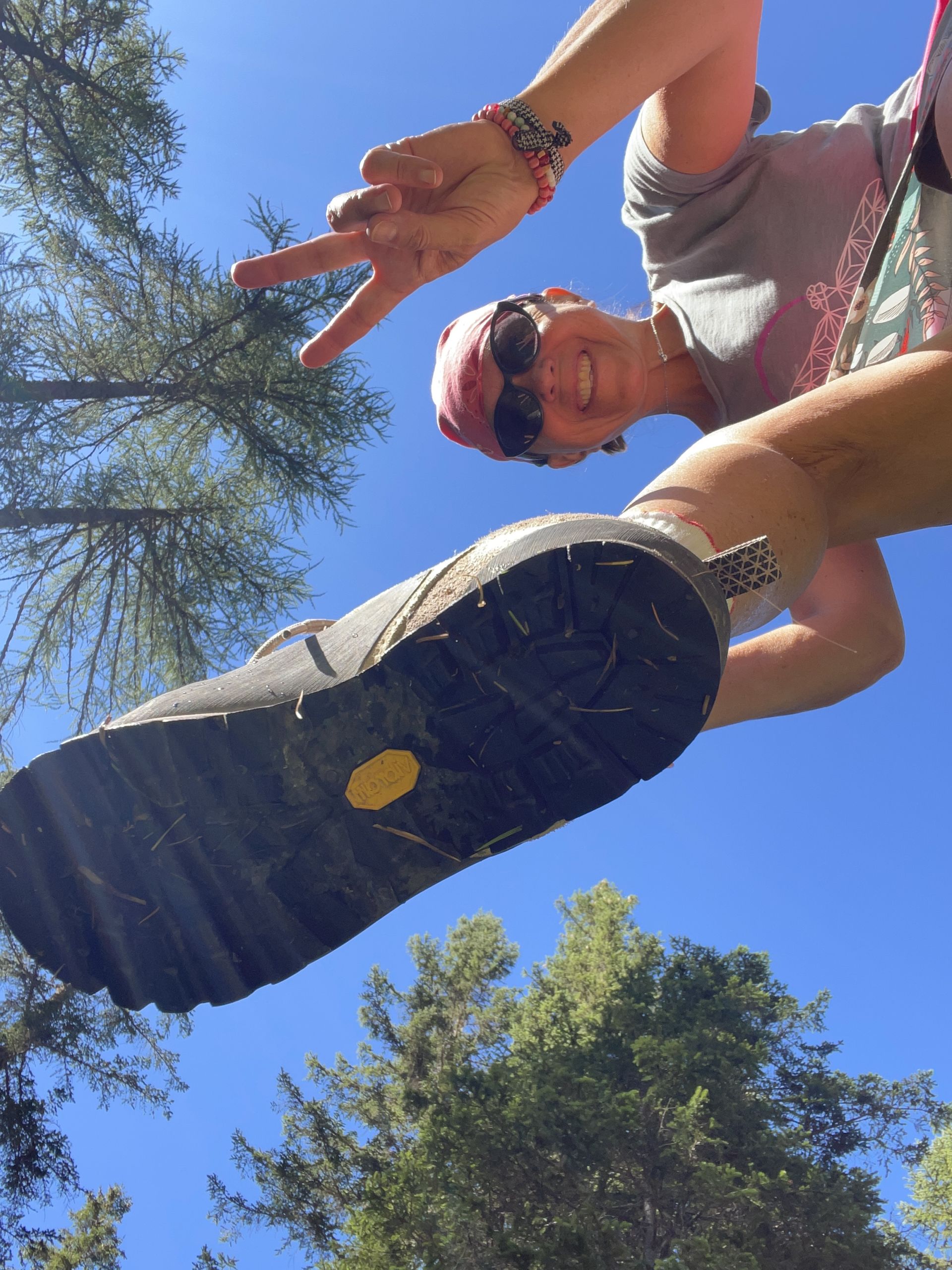Escursionista sorridente immortalata dal basso durante trekking in Italia