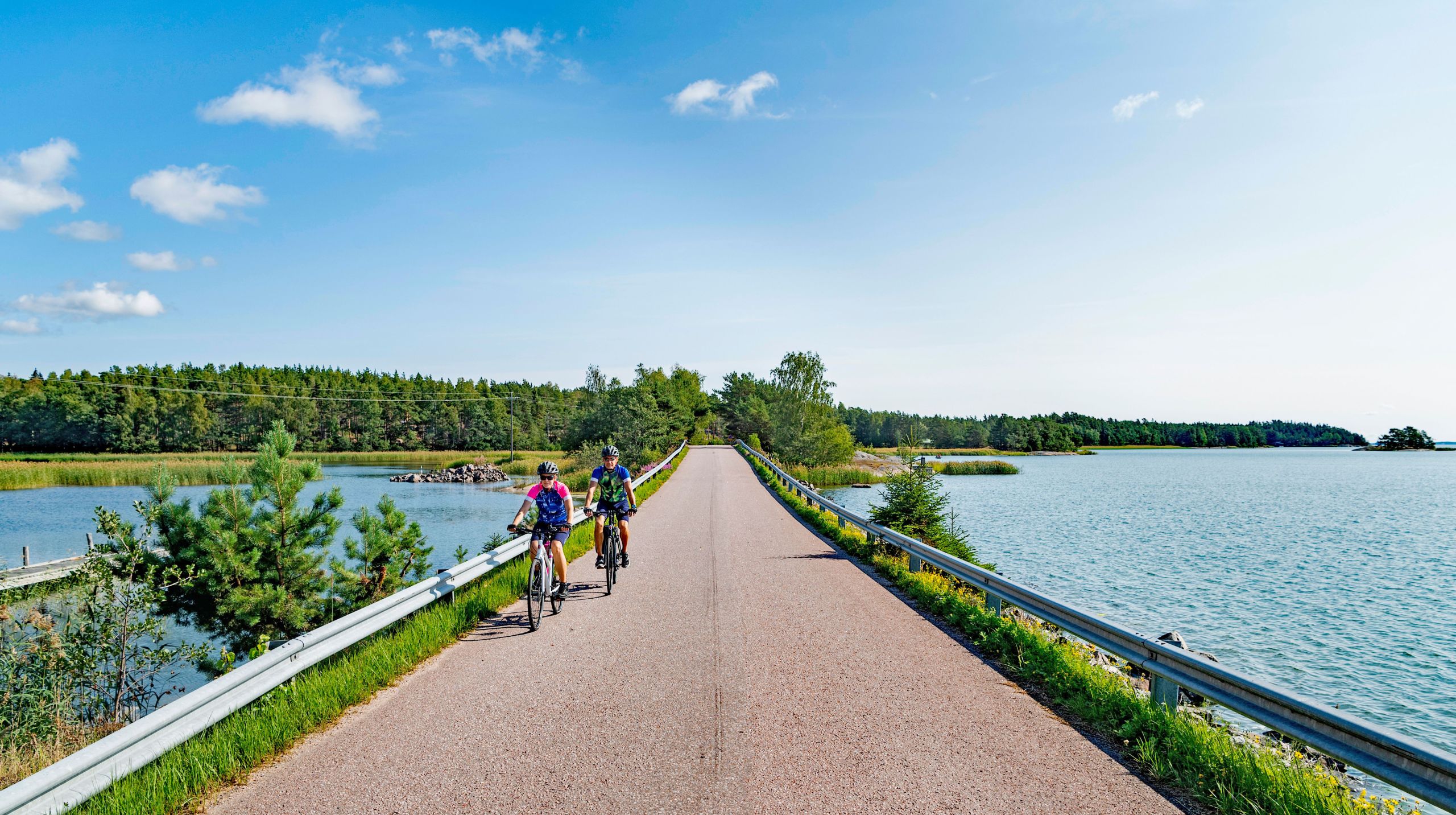 Ciclisti lungo una strada costiera immersa nella natura nell'arcipelago di Turku.