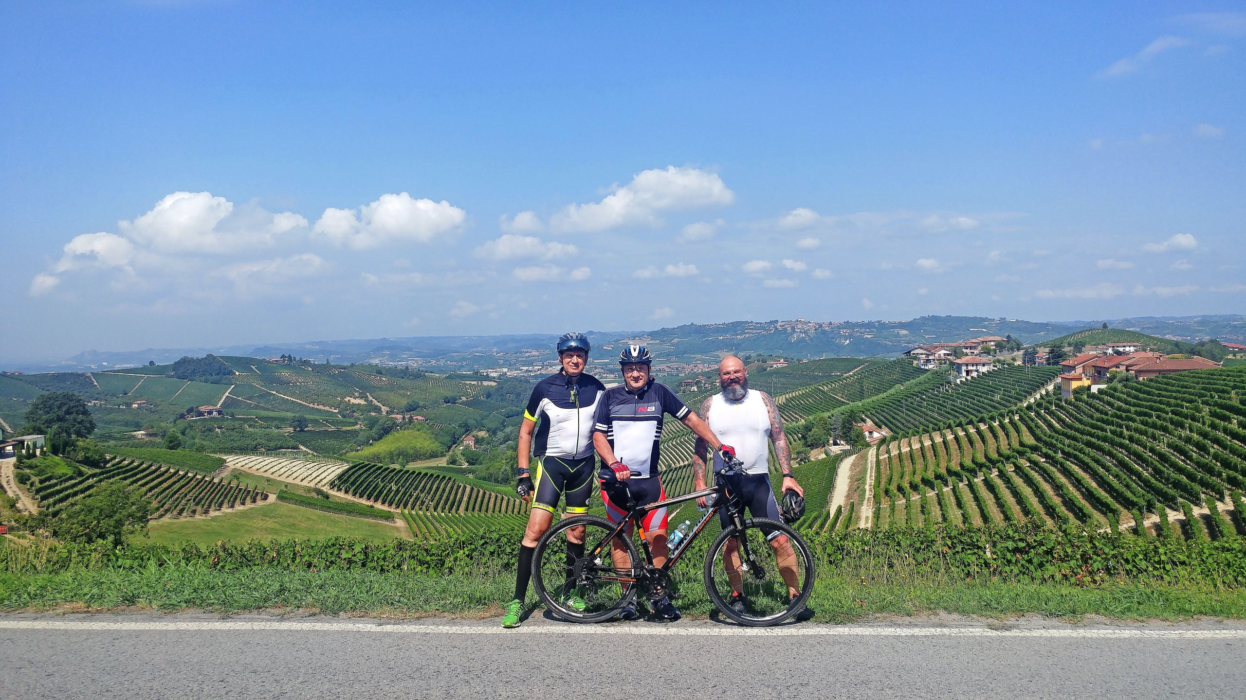 Group of cyclists cycling with Girolibero resting among vineyards in the Monferrato hills, Piedmont, Italy.
