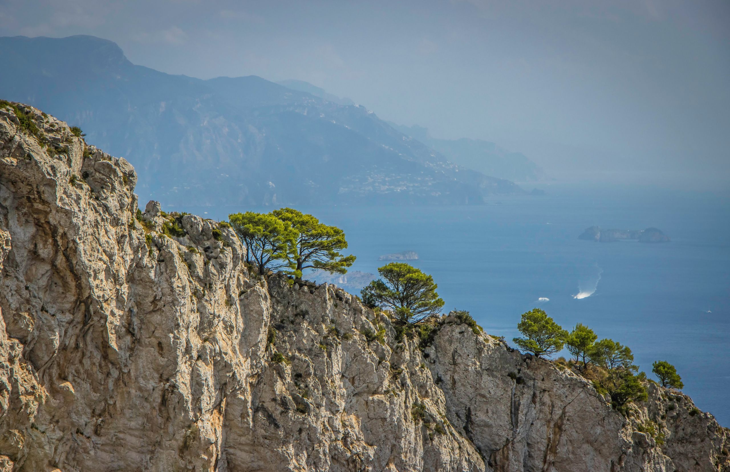 Vista panoramica della costa di Capri con il Vesuvio in lontananza, Italia.