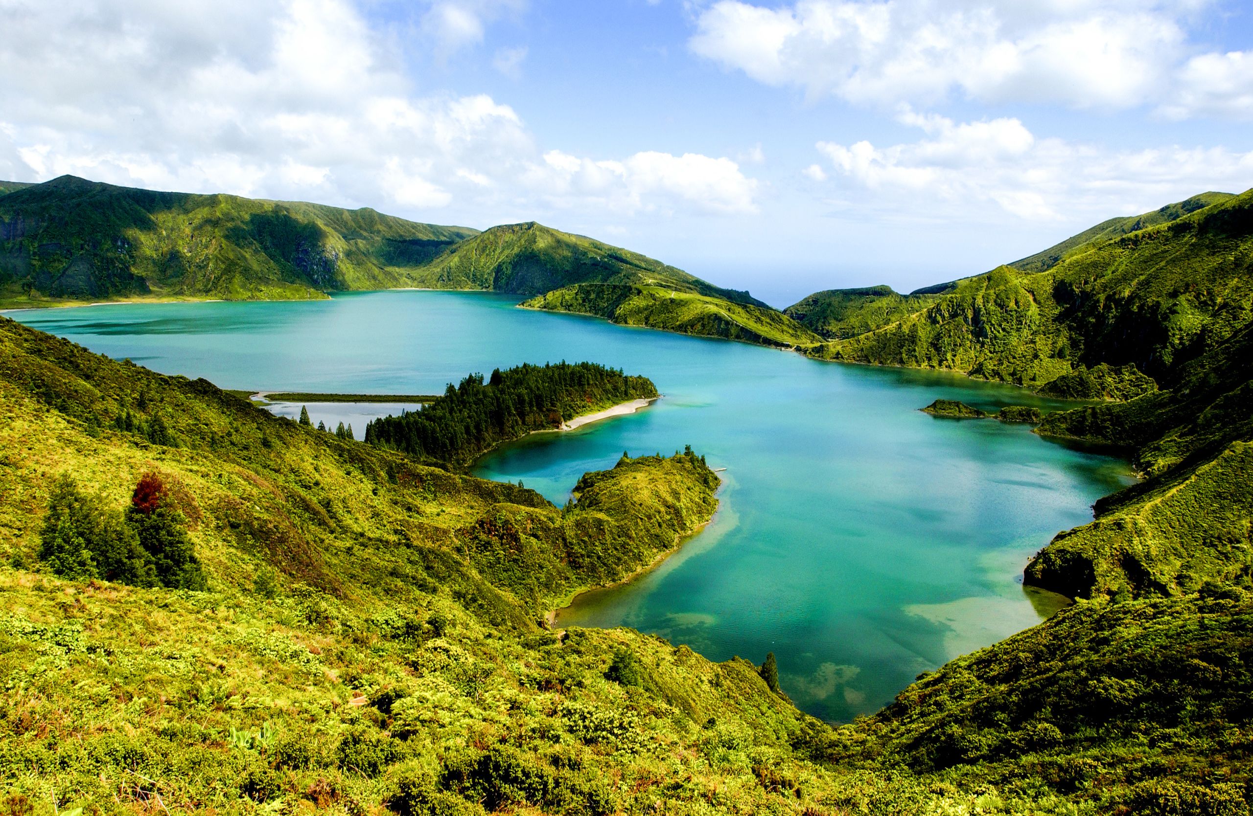 Escursionisti vicino a un lago panoramico circondato dal verde nell'Isola di San Miguel, Azzorre.