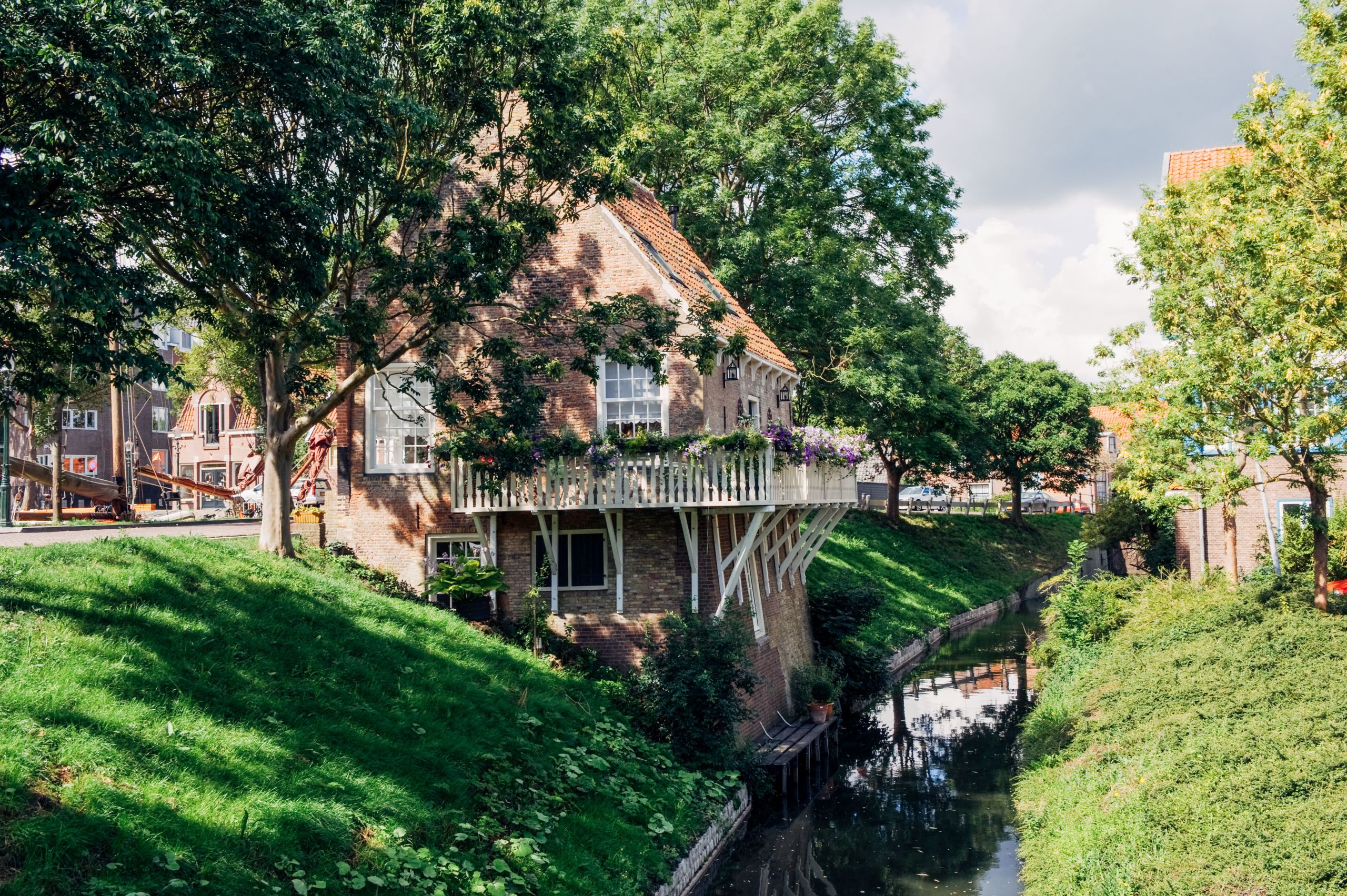 Kanal mit traditionellen Häusern, umgeben von Grün, in Giethoorn, Niederlande