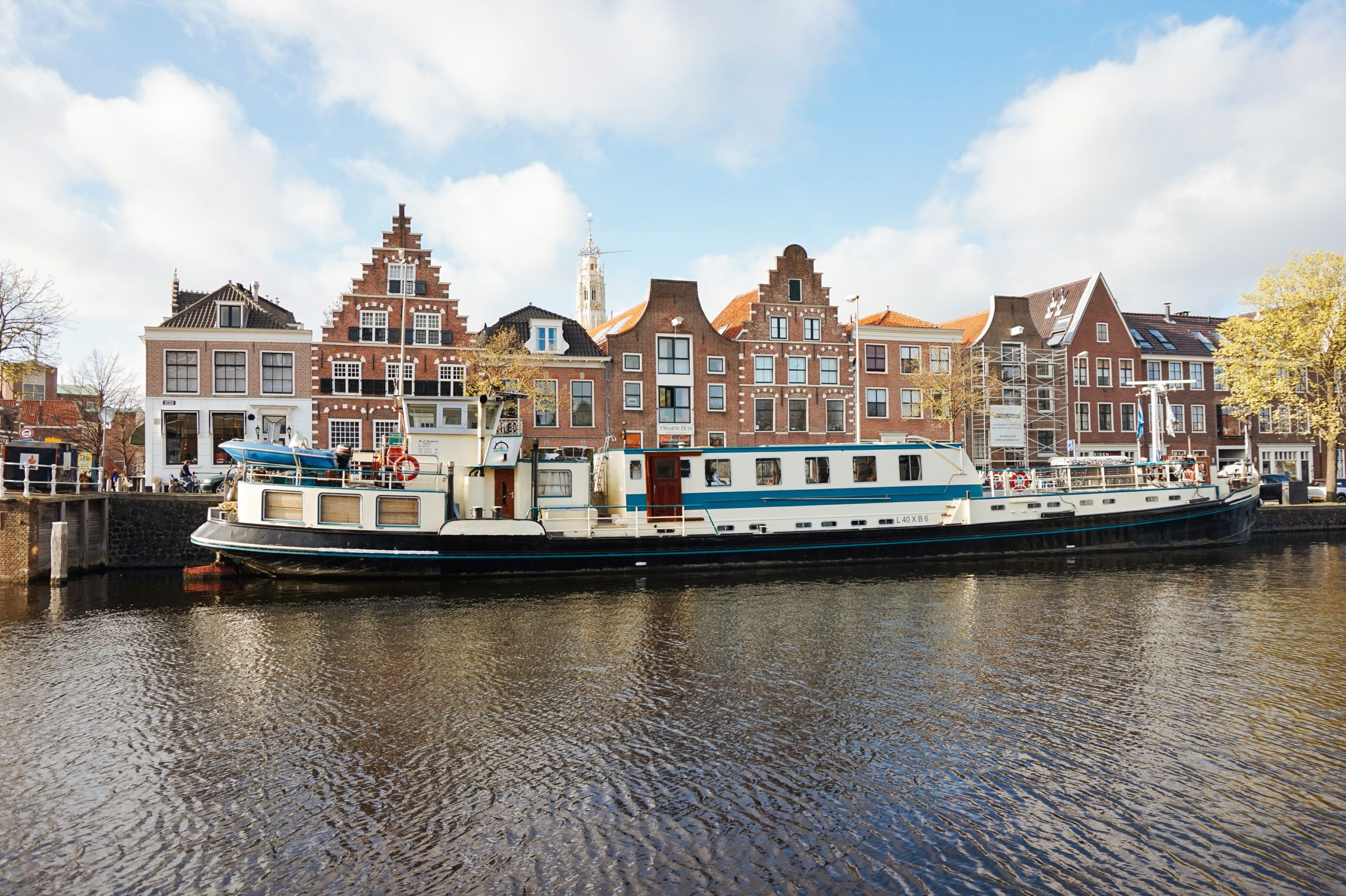 Case storiche lungo il canale di Hoorn con barca davanti in navigazione, Paesi Bassi.