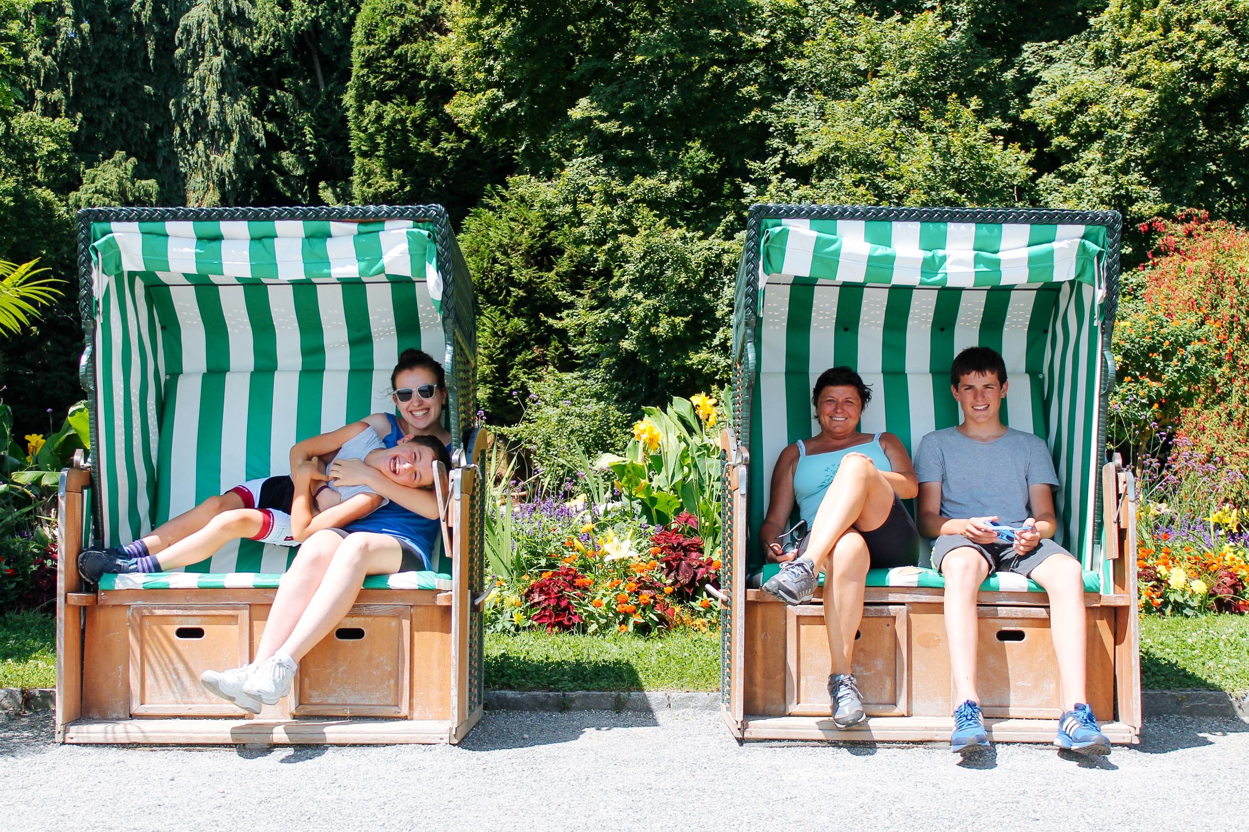 Famiglia di viaggiatori, panche verdi e bianche, riparo all'ombra, relax, vacanza all'aria aperta, lago di Costanza