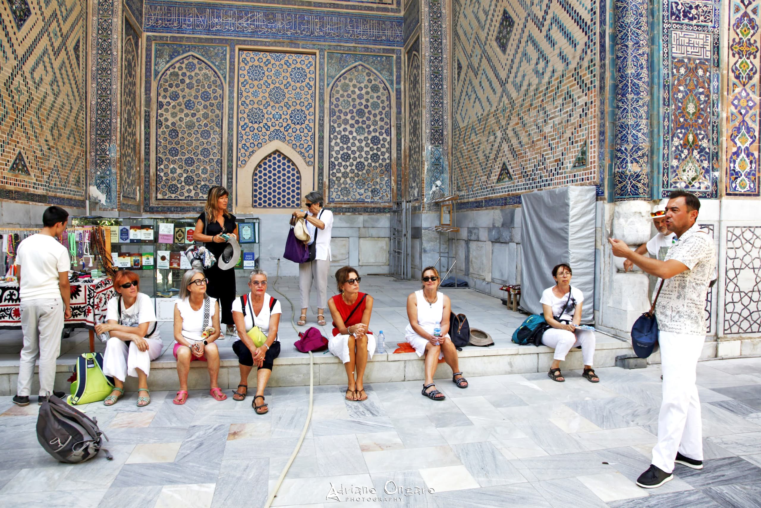 Visita guidata al complesso del Registan, Samarcanda: gruppo di viaggiatori ascolta la guida tra mosaici turchesi.