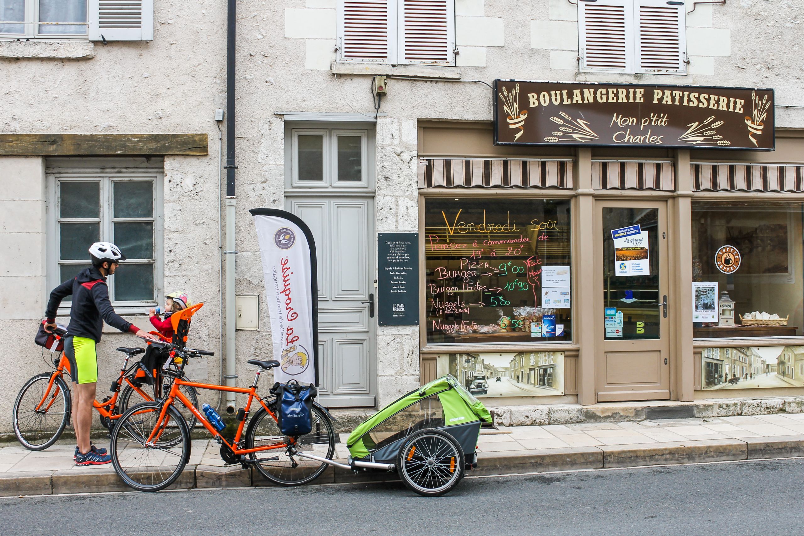 Cyclists taking a break in front of a shop in Chinon, France.