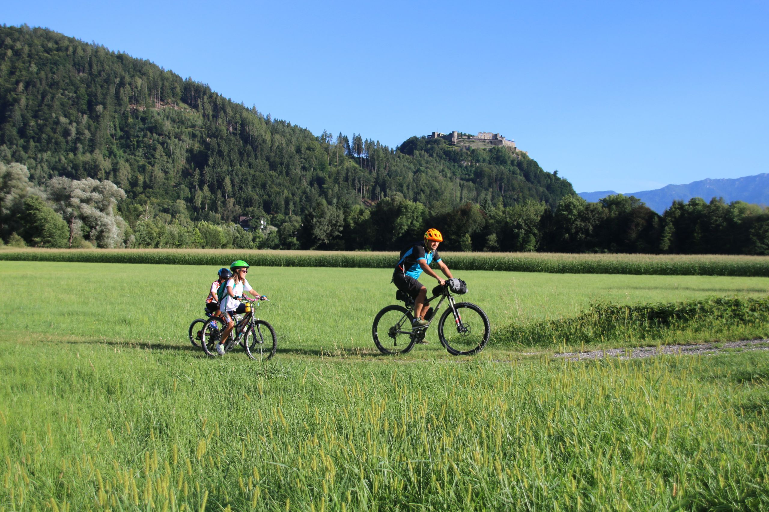 Famiglia con bambini, paesaggio verde di montagna, vacanza all'aria aperta, ciclabile della Drava, Austria