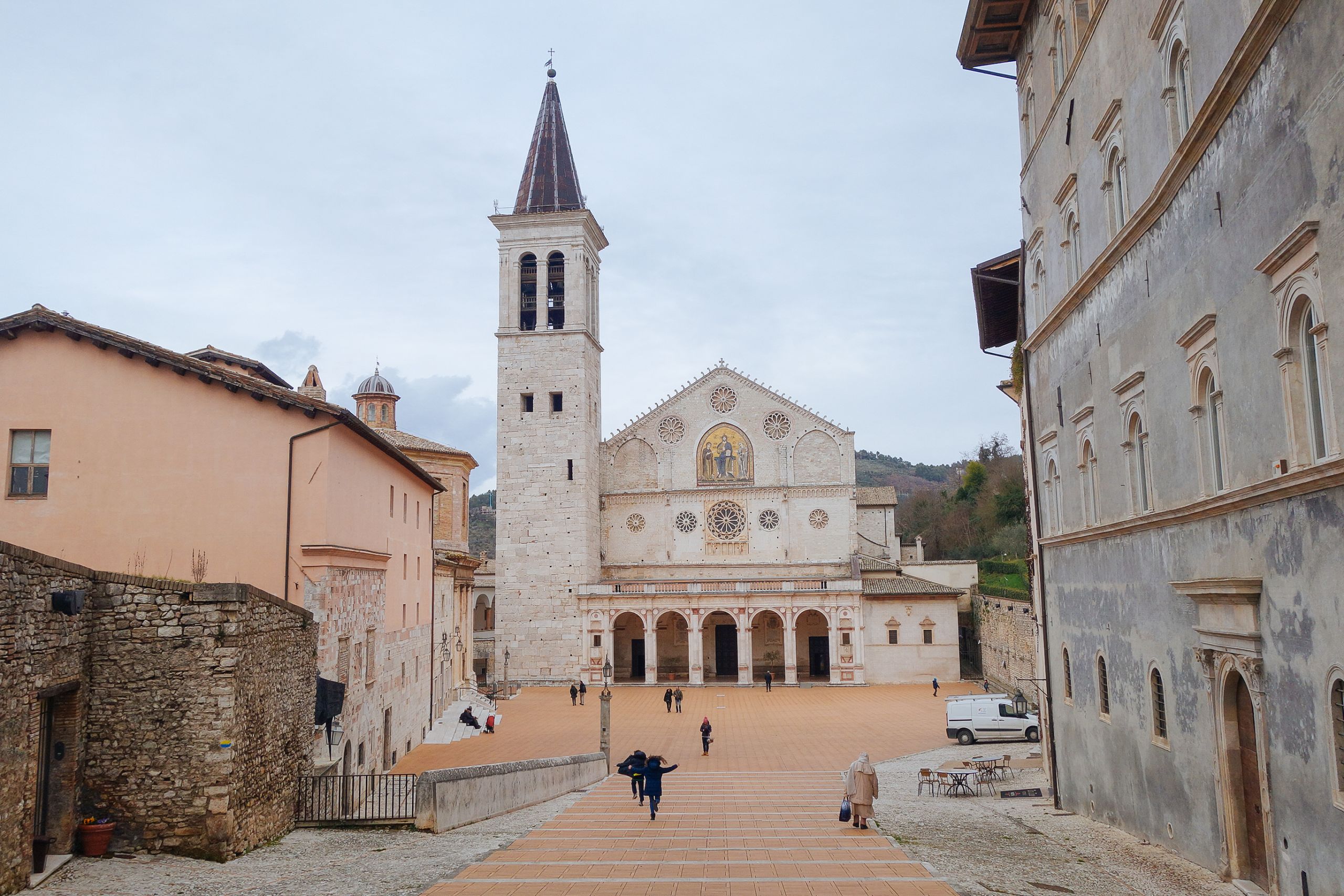 Piazza del Comune ad Assisi, con edifici storici e turisti.