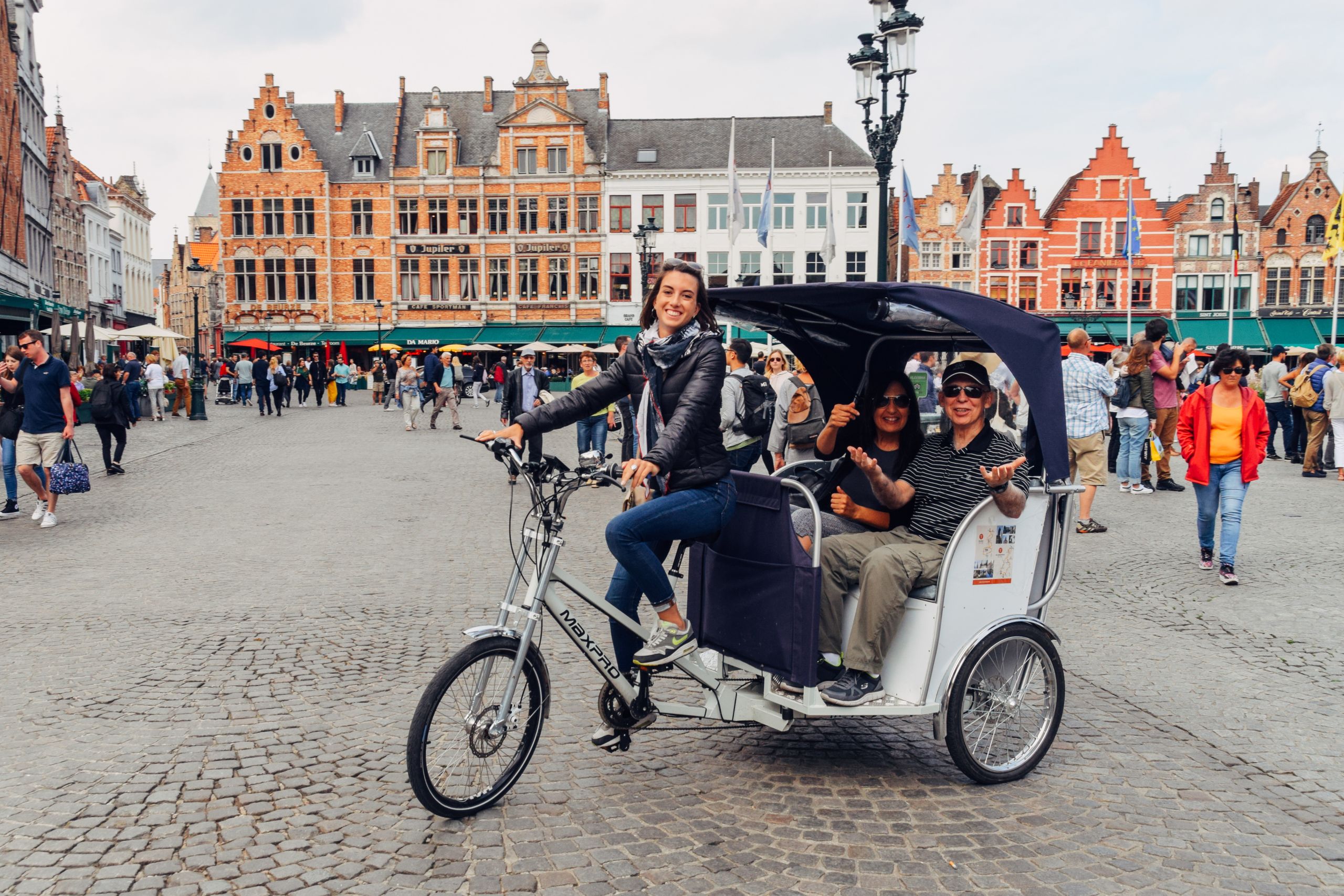 Familie auf einer Rikscha, die die Straßen von Brügge, Belgien, erkundet